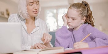 mother helps daughter who has a learning disability do her homework