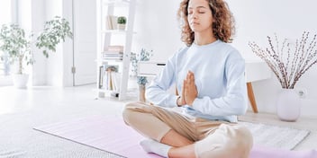 woman who is anxious finds relief by meditating in a peaceful room