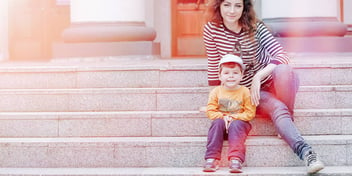 mother and son sitting on stairs outside a house