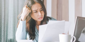 woman confused while reading over papers