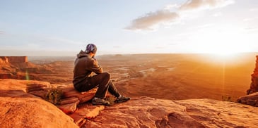 man contemplates life after divorce with hope as he watches the sun rise over mountains