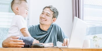 dad with son on his lap fills out his divorce forms on a computer