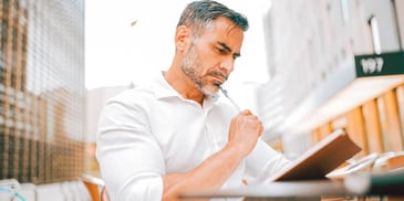 man thinking and writing