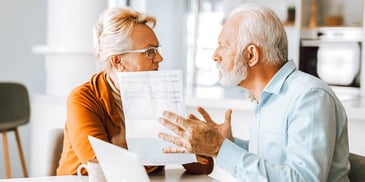 serious looking older couple arguing over paperwork