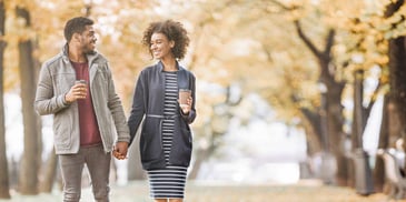 man and woman on a date walking in a park