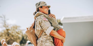 Woman hugs child when returning from military
