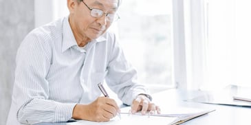 older man filling out paperwork to file for divorce