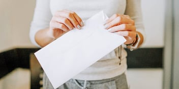 Woman holds envelope containing divorce forms served by mail