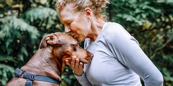 Woman kisses her dog on its head