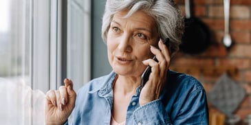 Older woman talks to her insurance broker on the phone